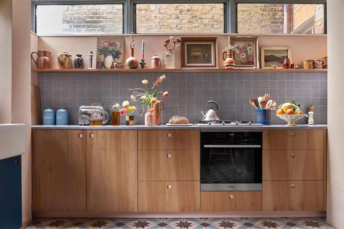Warm kitchen counter with a fruit bowl, bread, and a small jar of utensils