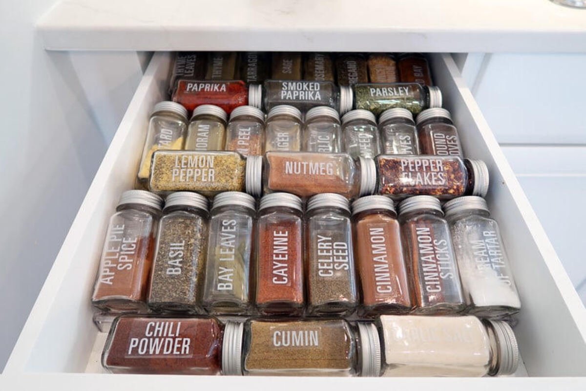 Labeled spice jars arranged in a kitchen drawer
