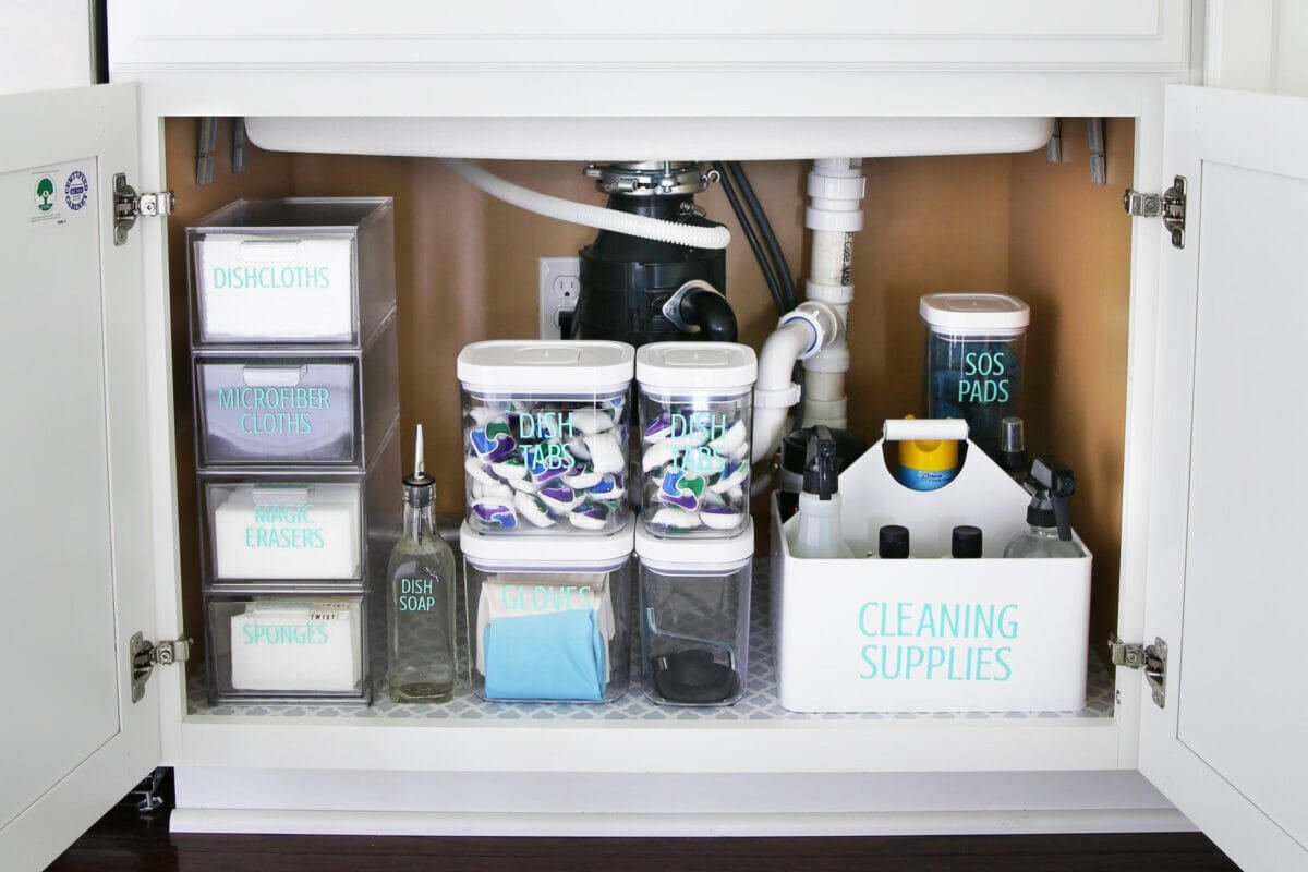 Under-sink cabinet with labeled bins for cloths, soap, and cleaning supplies